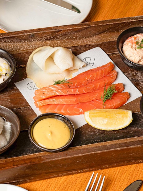 Assorted seafood platter with salmon, herring, and sauces at Flora Danica, Champs Elysées, Paris.