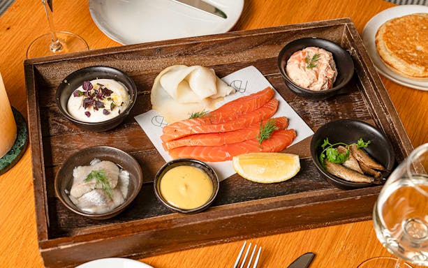 Assorted seafood platter with salmon, herring, and sauces at Flora Danica, Champs Elysées, Paris.