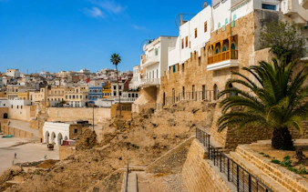 Tangier Medina stone walls and historic buildings under a clear blue sky.