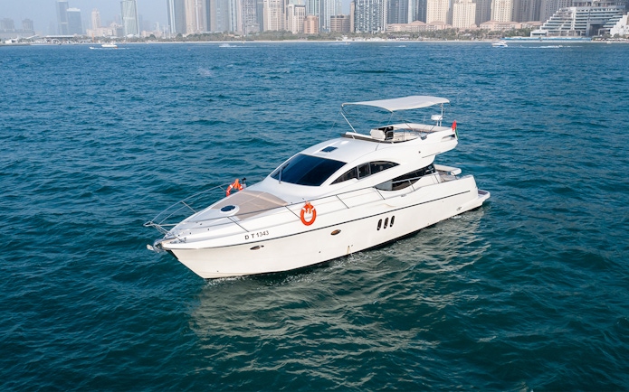 Private yacht Veronika 55 cruising in Dubai with city skyline in background.
