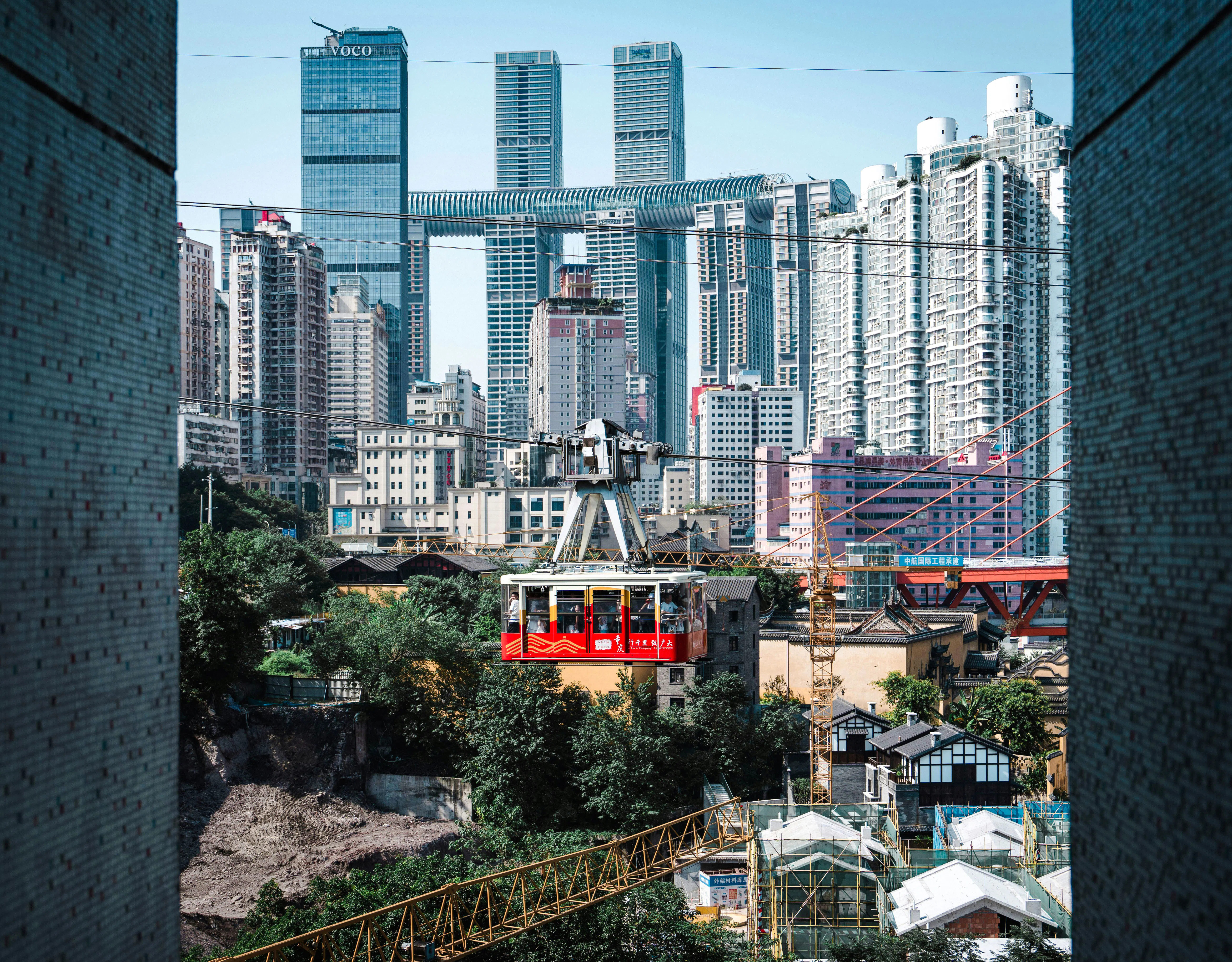 Chongqing skyline with cable car crossing over city buildings.