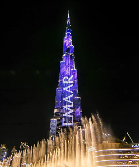 Dubai Fountain show with Burj Khalifa illuminated at night.