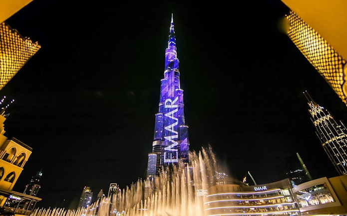 Dubai Fountain show with Burj Khalifa illuminated at night.