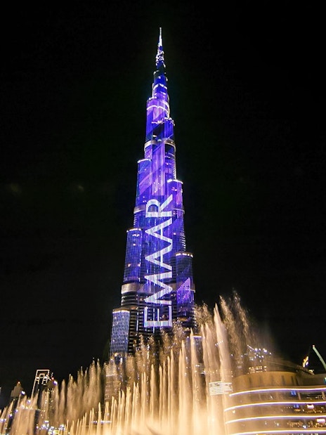 Dubai Fountain show with Burj Khalifa illuminated at night.