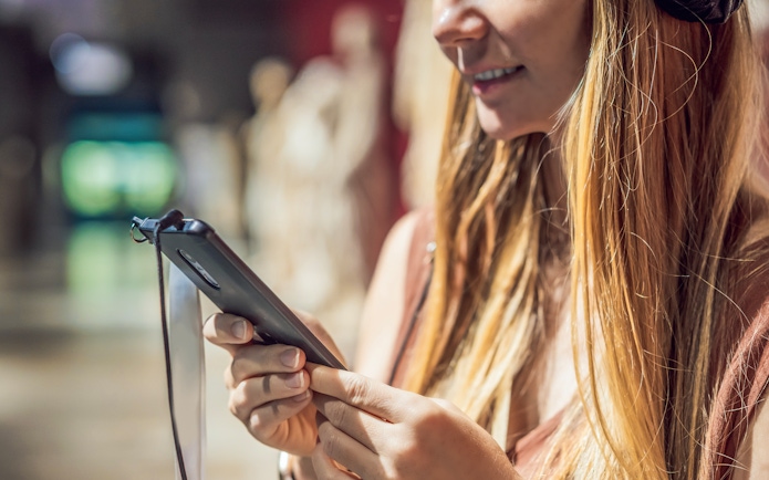 Woman using audio guide in museum.