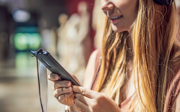 Woman using audio guide in museum.