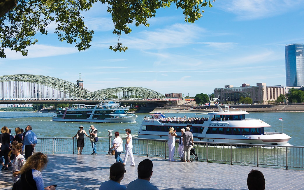 Cruise boats on the Rhine River with Hohenzollern Bridge in Cologne.