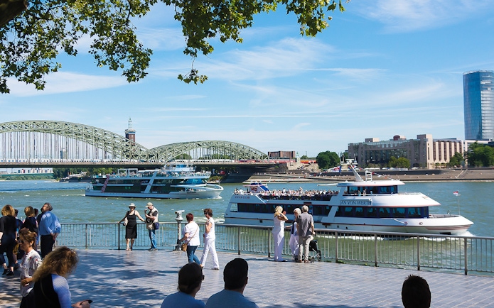 Cruise boats on the Rhine River with Hohenzollern Bridge in Cologne.