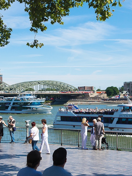 Cruise boats on the Rhine River with Hohenzollern Bridge in Cologne.