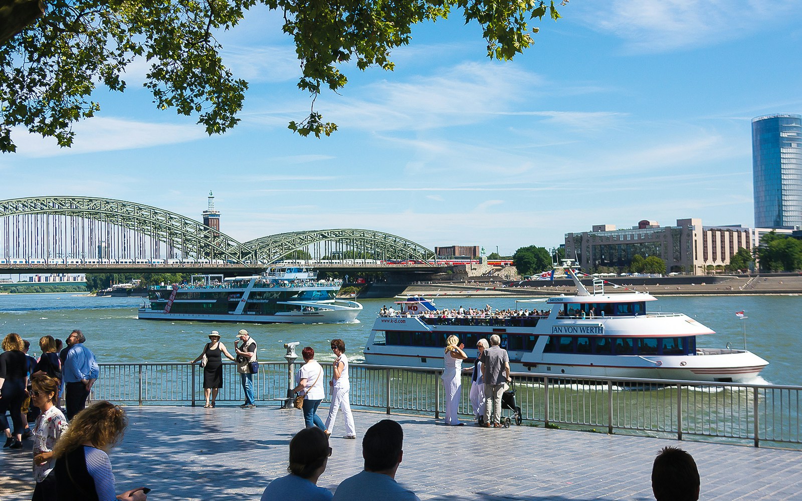 Cruise boats on the Rhine River with Hohenzollern Bridge in Cologne.