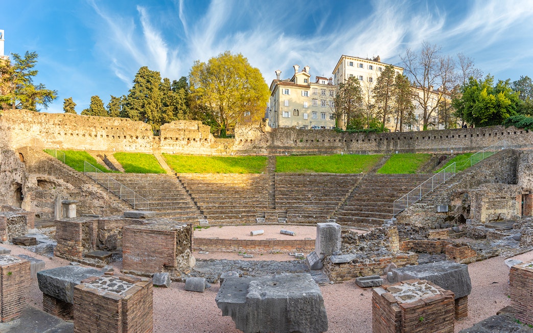 Ancient Roman amphitheater in Verona with stone ruins and tiered seating.