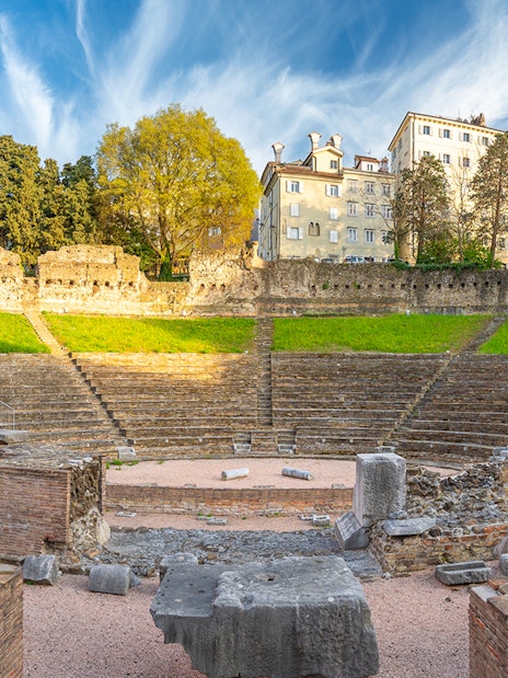 Ancient Roman amphitheater in Verona with stone ruins and tiered seating.