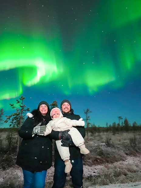 Guests viewing Northern Lights on a bus tour in Rovaniemi.