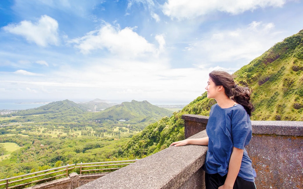 Woman enjoying the view at Nuuanu Pali Lookout, Oahu, Hawaii.