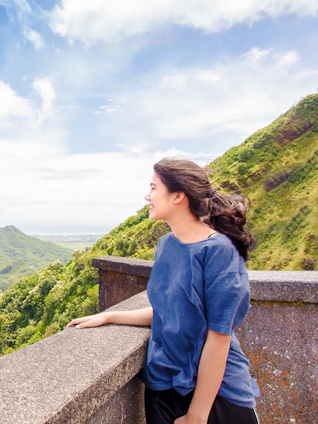 Woman enjoying the view at Nuuanu Pali Lookout, Oahu, Hawaii.