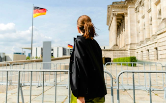 Guest exploring the Reichstag building in Berlin with German flag in view.