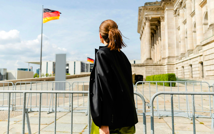 Guest exploring the Reichstag building in Berlin with German flag in view.