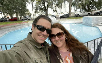 Couple smiling by a fountain in Savannah during the self-guided city exploration game.