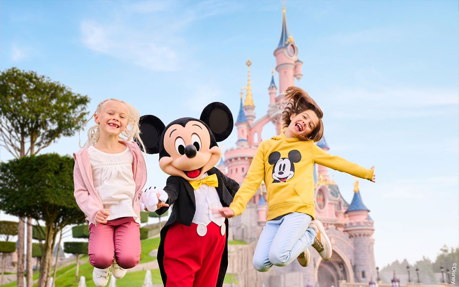 Mickey Mouse with two kids jumping in front of Sleeping Beauty Castle, Disneyland Paris.