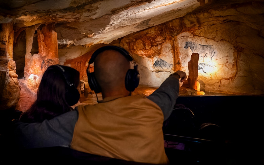 Visitors with headphones view prehistoric cave paintings in Cosquer Cave, Marseille.