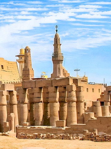 Luxor Temple ancient columns and mosque minaret under a clear blue sky in Egypt.