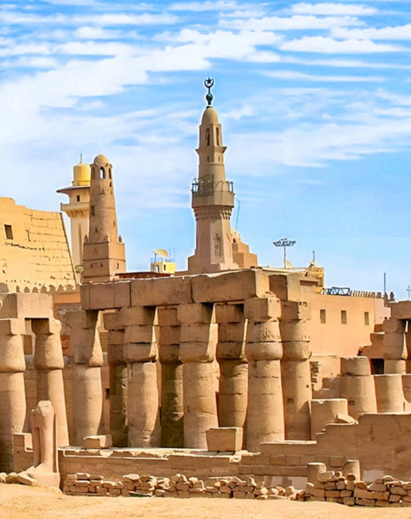 Luxor Temple ancient columns and mosque minaret under a clear blue sky in Egypt.