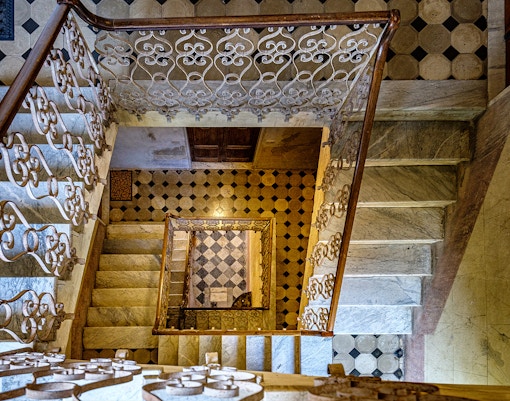 Palazzo Vecchio marble stairs with ornate railing and geometric floor tiles.