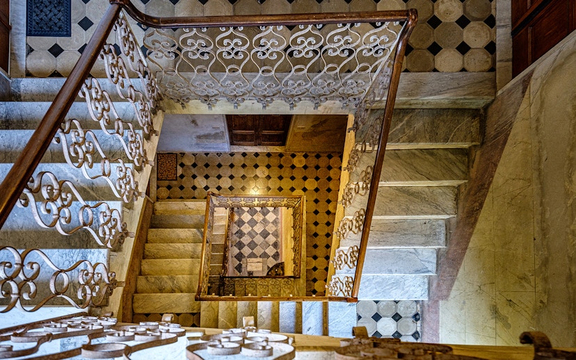 Palazzo Vecchio marble stairs with ornate railing and geometric floor tiles.