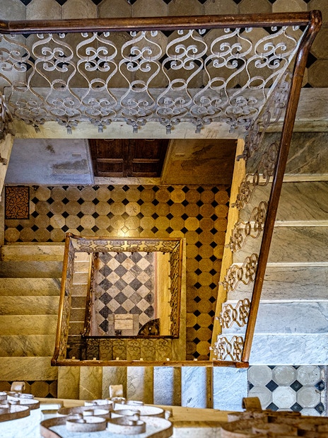 Palazzo Vecchio marble stairs with ornate railing and geometric floor tiles.