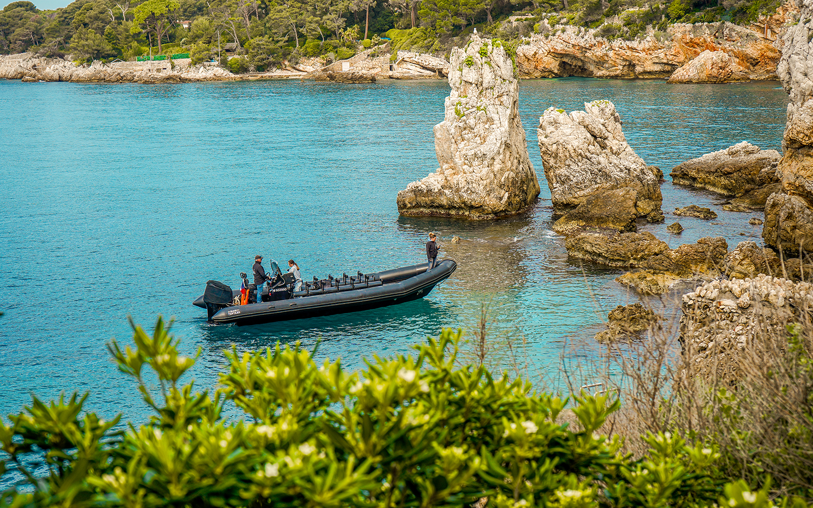 Boat near rocky coastline during Paddle Eclipse excursion from Théoule-sur-Mer.