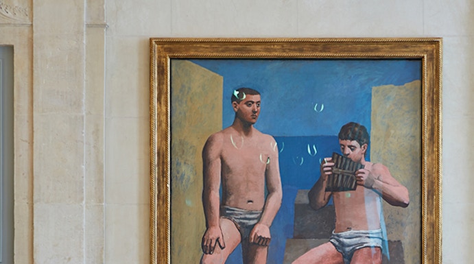 Visitors viewing a painting at Musée Picasso in Paris.