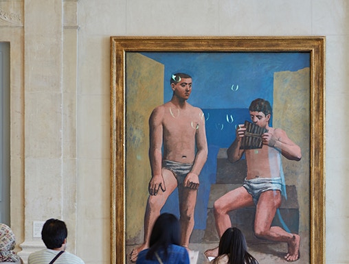 Visitors viewing a painting at Musée Picasso in Paris.