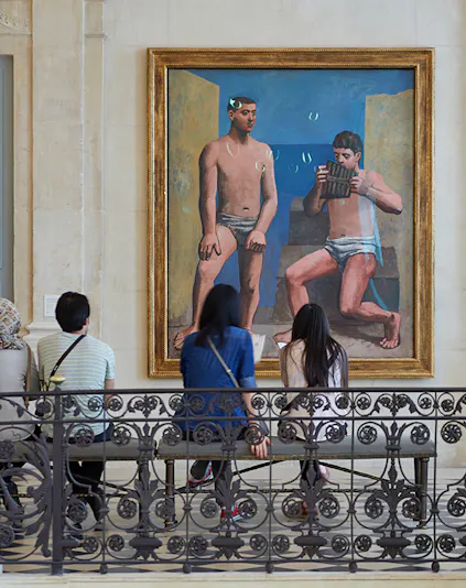 Visitors viewing a painting at Musée Picasso in Paris.