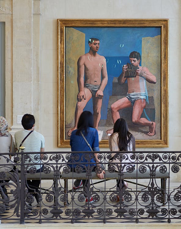 Visitors viewing a painting at Musée Picasso in Paris.
