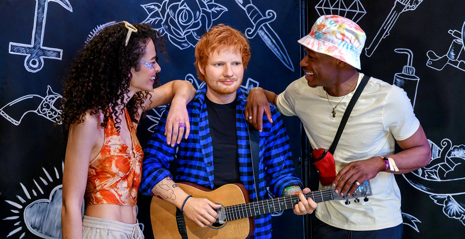 Couple posing with Ed Sheeran's wax statue at Madame Tussauds in London