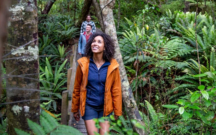 Tourists walking through lush forest on Ulva Island.