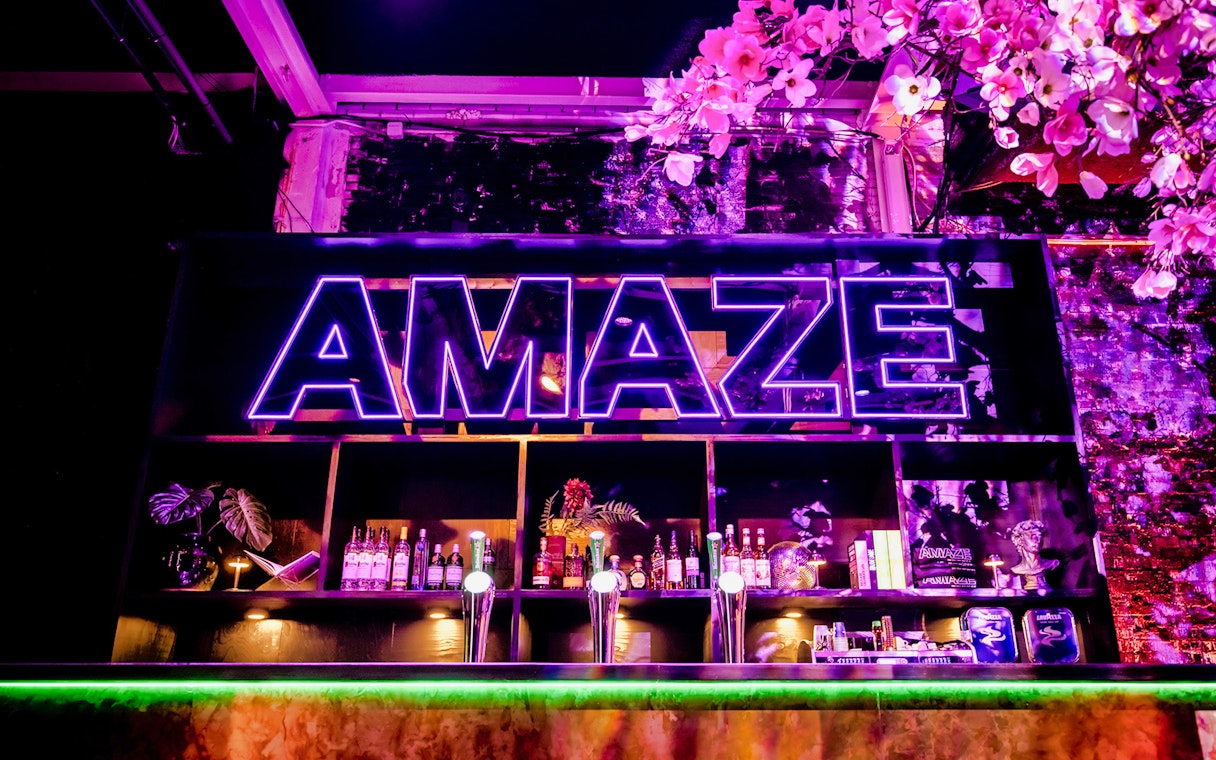 Bar setup with neon Amaze sign in Amsterdam.