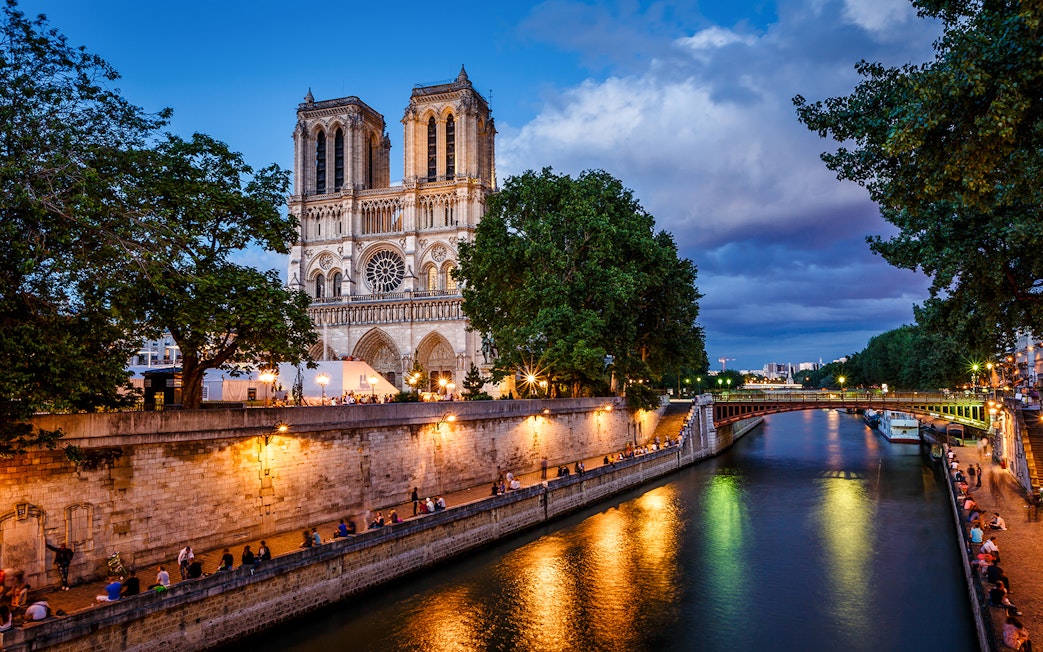 Notre Dame Cathedral and Seine River at dusk in Paris.