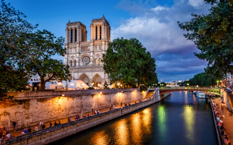 Notre Dame Cathedral and Seine River at dusk in Paris.