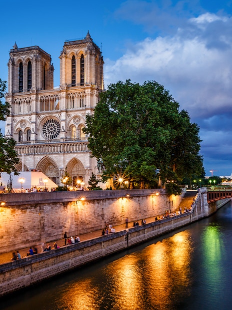 Notre Dame Cathedral and Seine River at dusk in Paris.