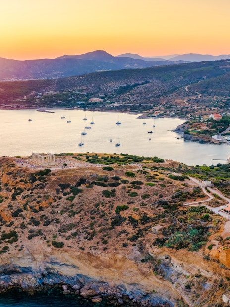 Aerial view of Cape Sounion bay with Temple of Poseidon at sunset, Greece.