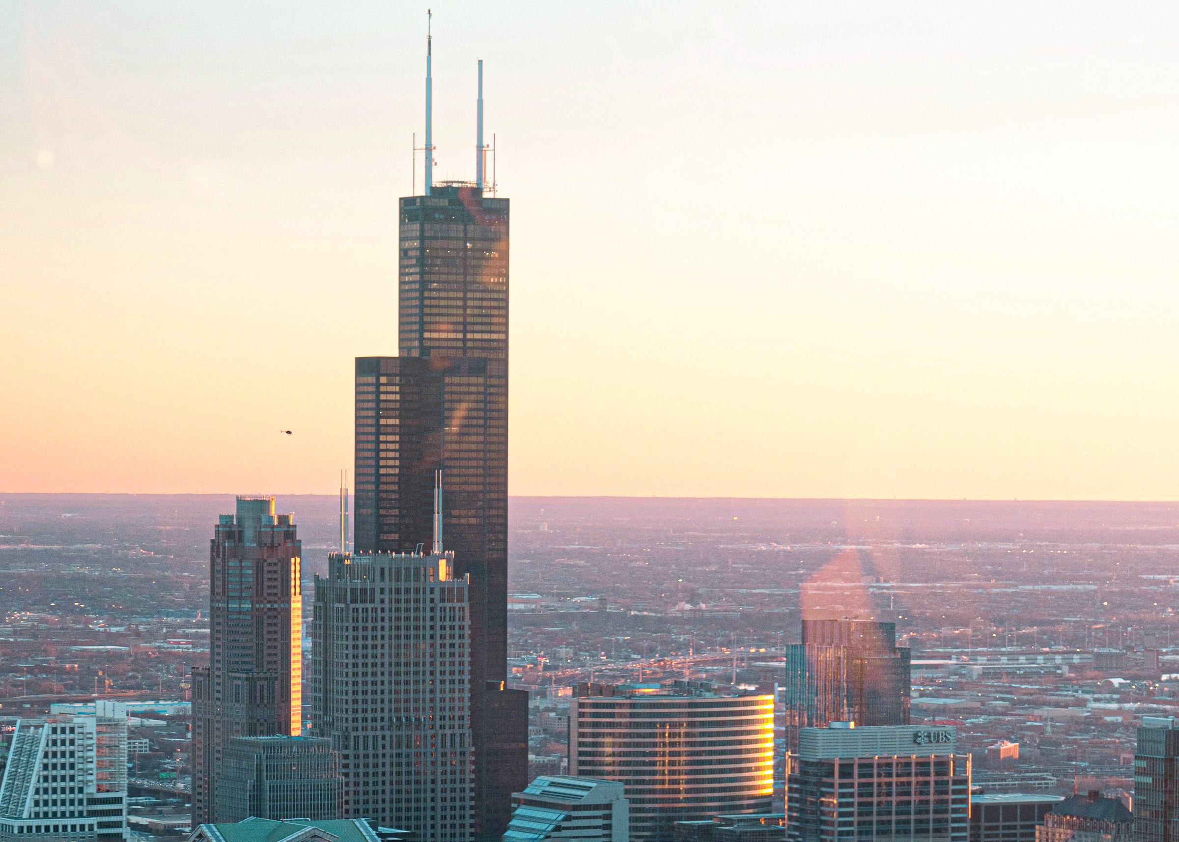 The exterior of 360 Chicago with its two antenna sprawling in the sky during a rainy weather.
