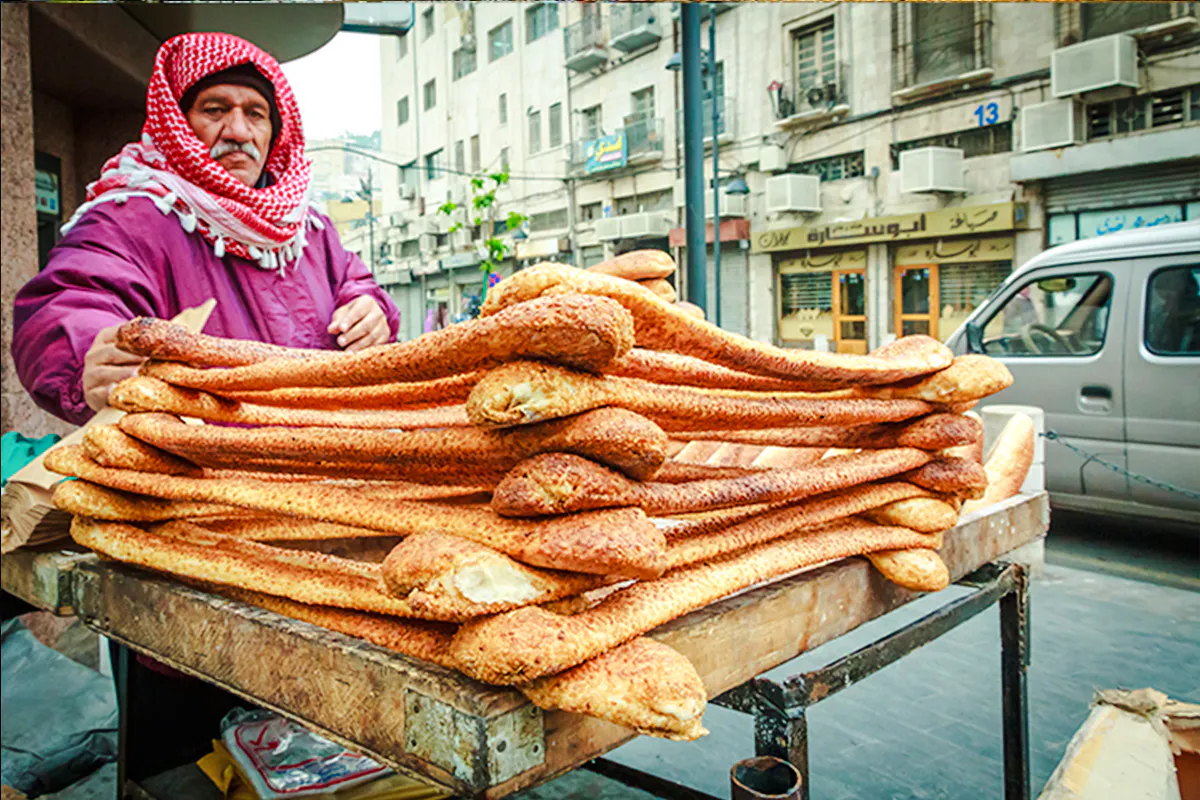 Street vendor selling traditional bread in Amman during city sightseeing tour.
