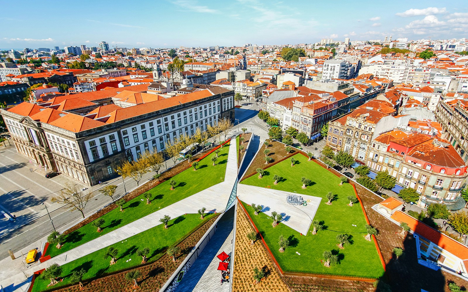 Aerial view of Porto cityscape with red rooftops and green park near Clerigos Tower.