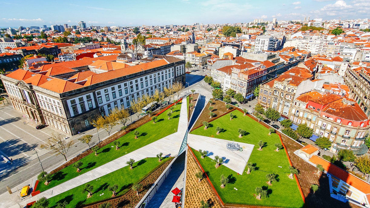 Aerial view of Porto cityscape with red rooftops and green park near Clerigos Tower.
