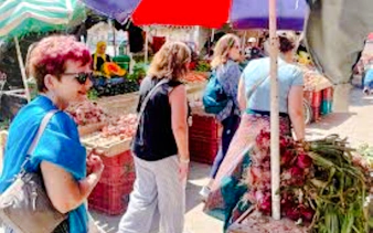 Visitors exploring a vibrant market in Nairobi, surrounded by fresh produce and local vendors.