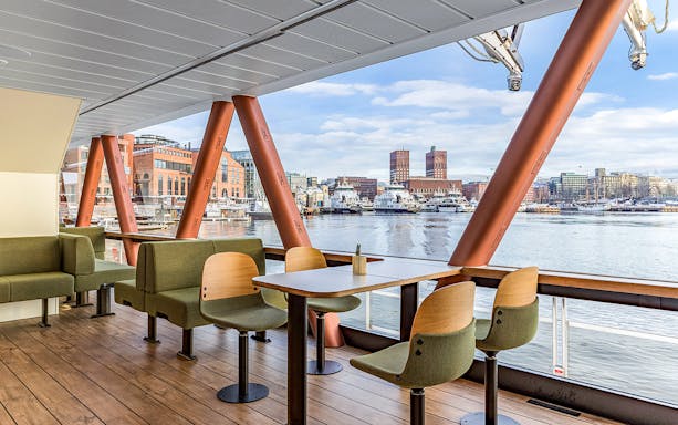 Brunch seating on a boat with Oslo waterfront and city hall view.