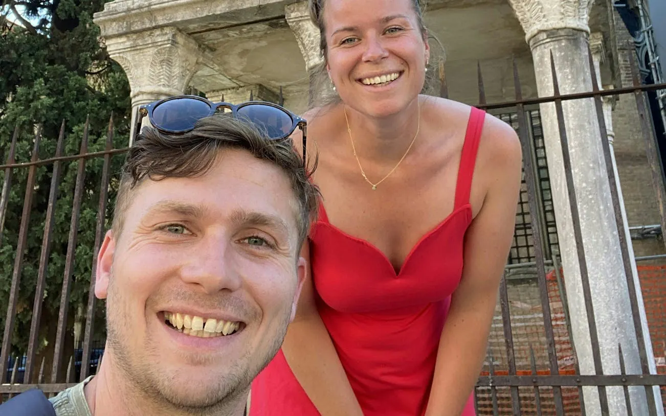 Tourists smiling in front of historic columns during Bologna city exploration game.