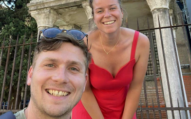Tourists smiling in front of historic columns during Bologna city exploration game.