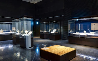 Artefacts displayed in glass cases at Kyushu National Museum exhibition hall.